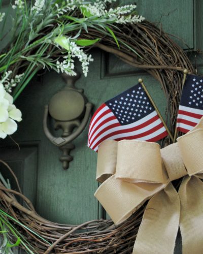 This DIY Spring Wreath easily transitioned to a beautiful simmer wreath with the addition of a burlap bow and a couple of American flags.