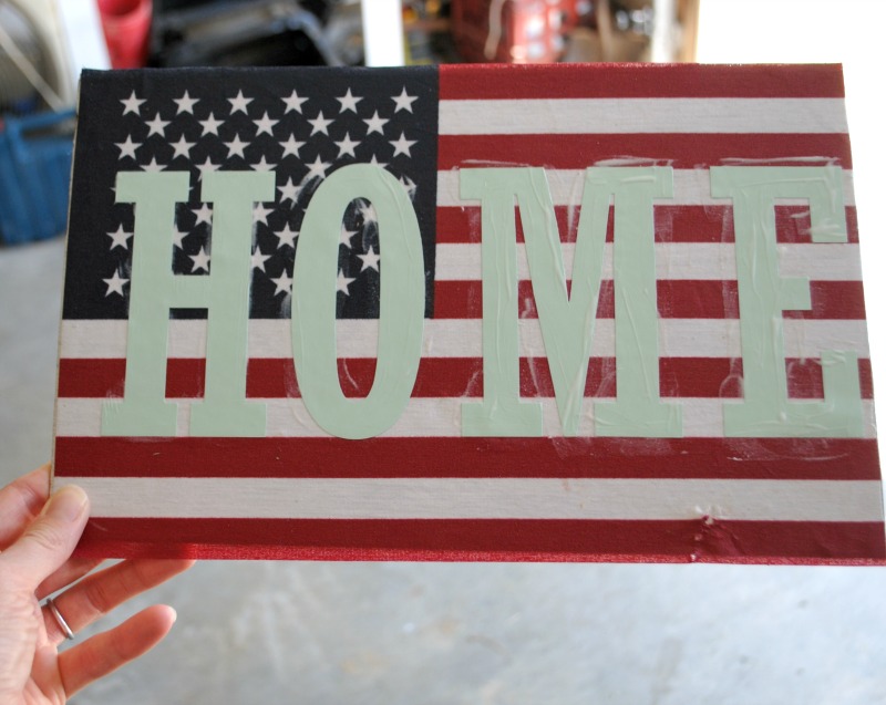 Use a cricut to cut out vinyl letters to create custom message on a DIY patriotic flag sign. 